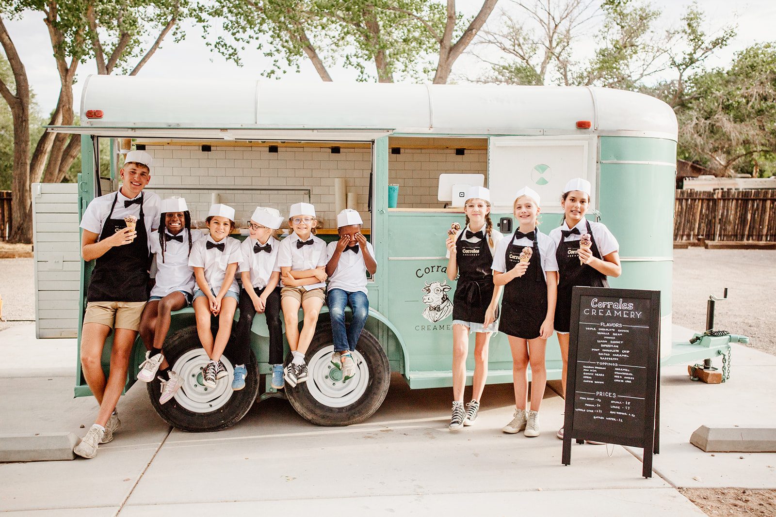The full Corrales Creamery crew of young servers lined up in front of the mint-green trailer