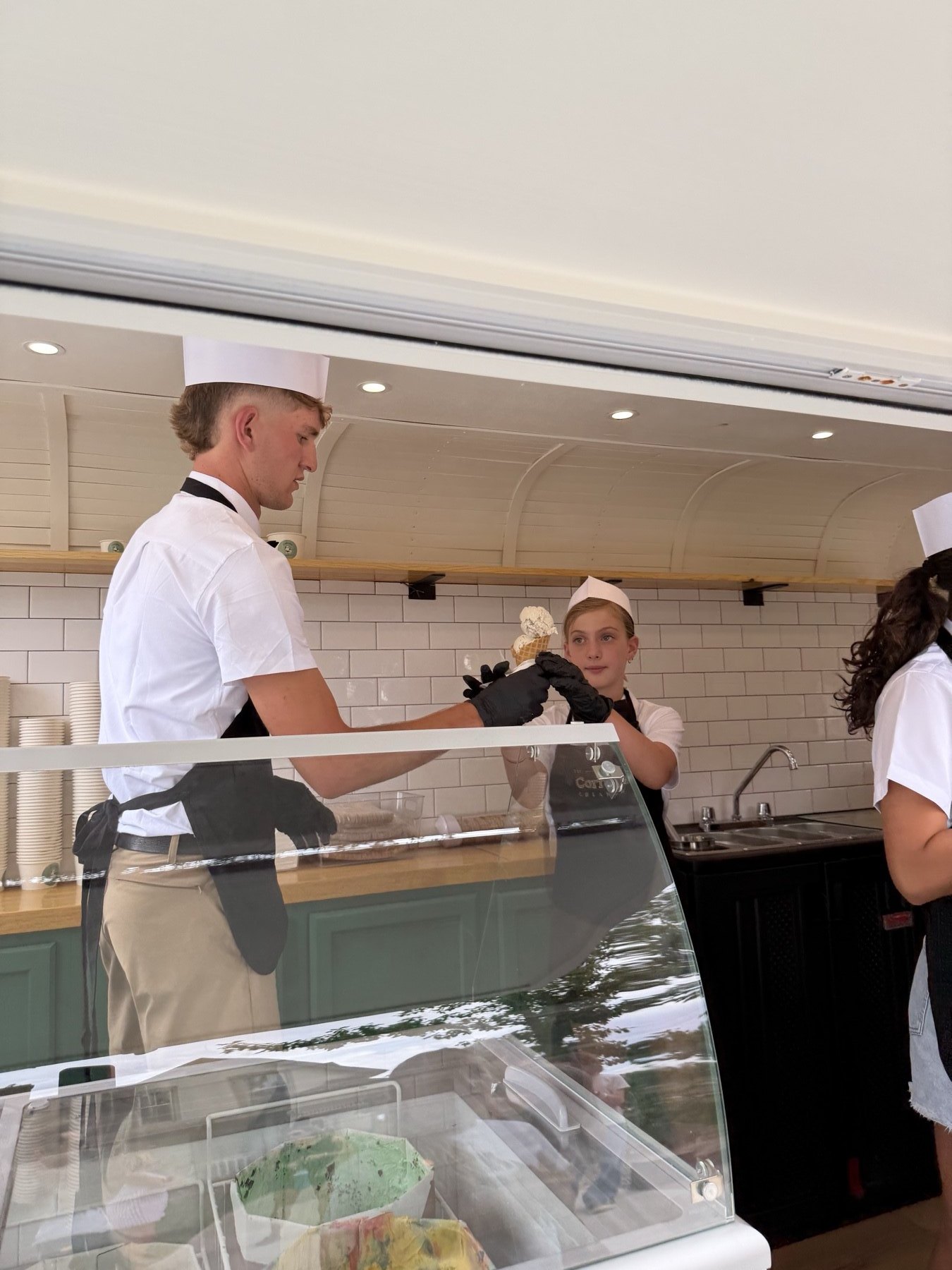 Corrales Creamery crew scooping ice cream inside the trailer